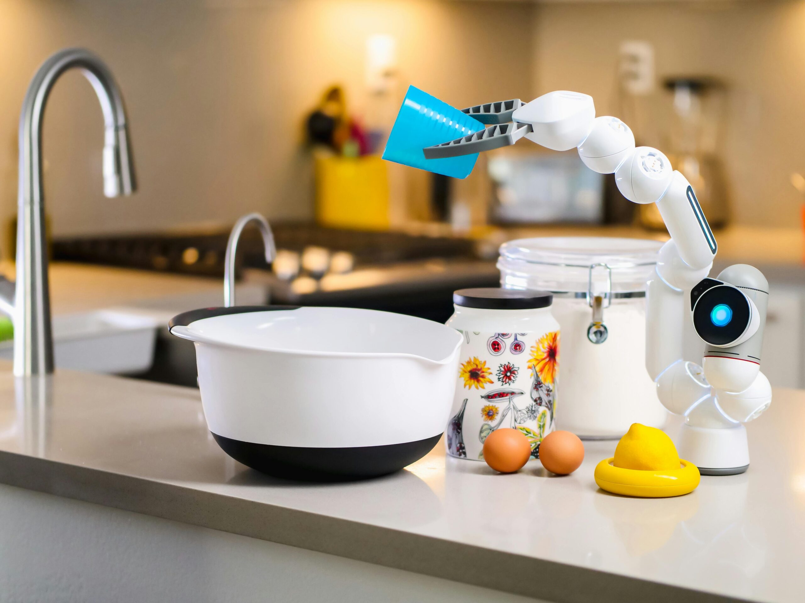 pexels-photo-9028881-9028881 A robotic arm assists with mixing ingredients in a modern kitchen, showcasing advanced home technology.